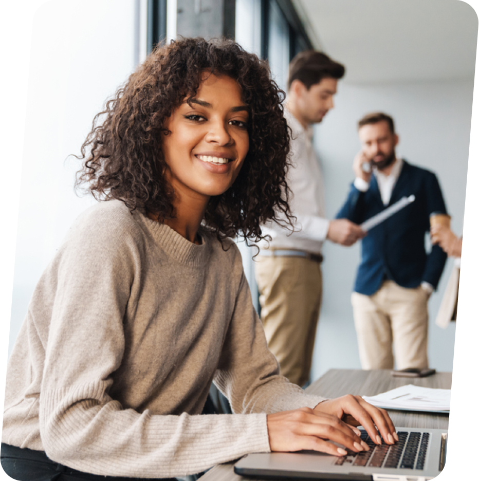 image of women smiling while working on laptop